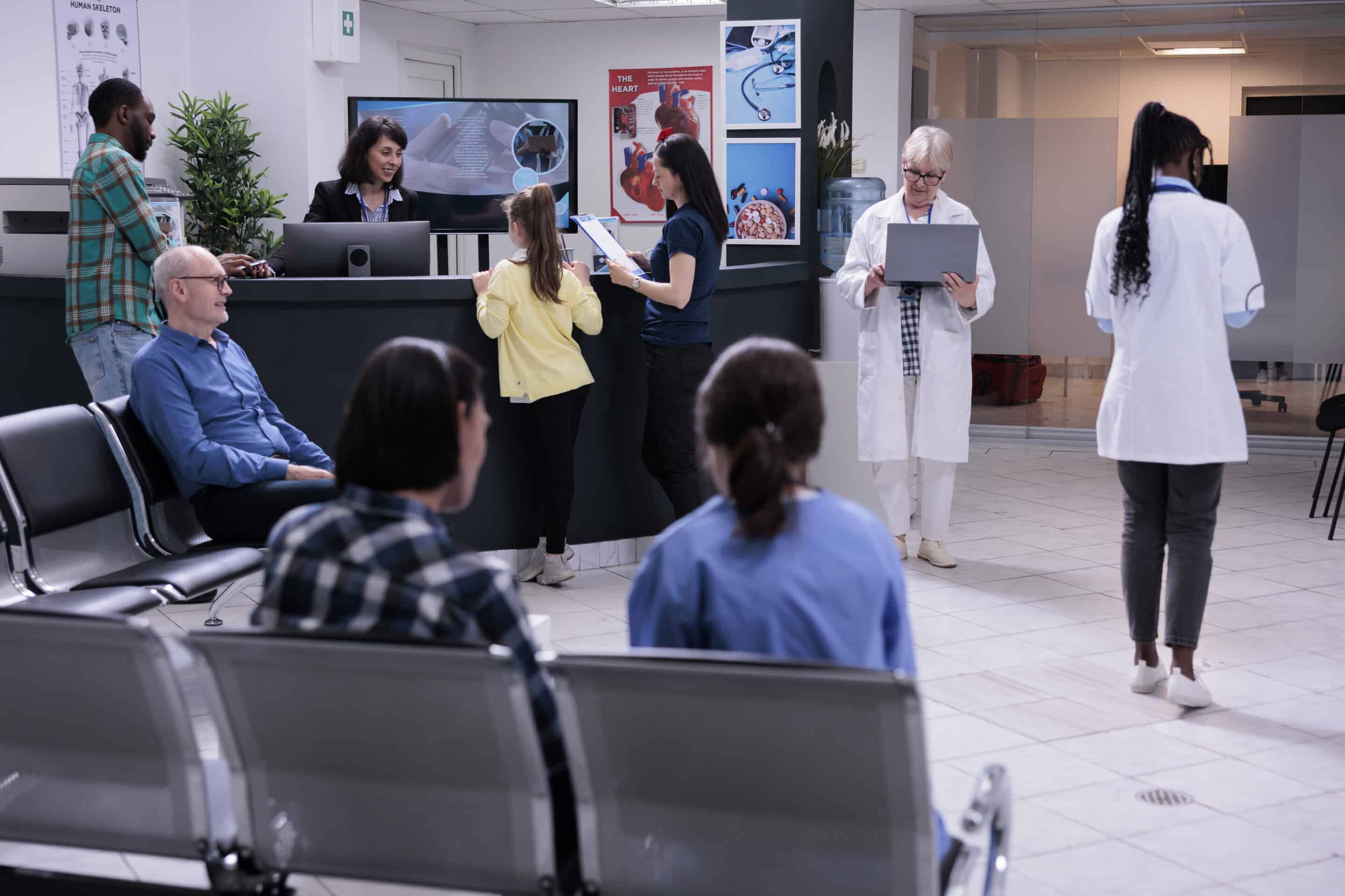 Senior Doctor Holding Laptop Computer In Modern Clinic Reception